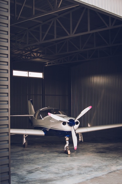 Foto piccolo jet privato bianco parcheggiato nell'hangar