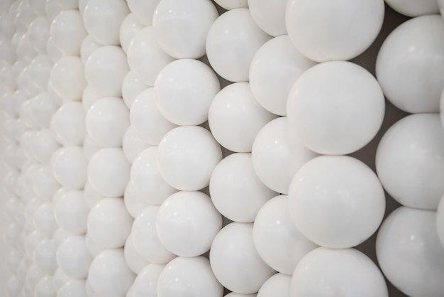 Small white spheres and flat circle shapes wall for Interior design.