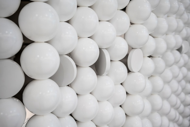 Photo small white spheres and flat circle shapes wall for interior design.