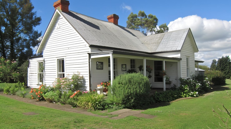 Photo small white wooden cottage with a garden and a porch