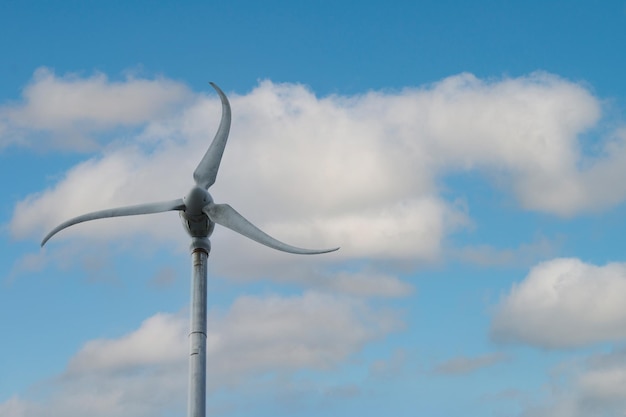 Небольшая ветряная турбина в голубом небе экологически чистая энергия для людей
