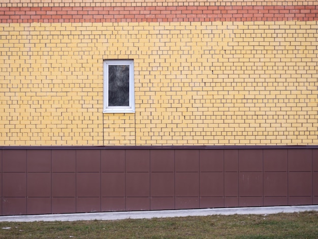 A small window in a brick wall Colored bricks