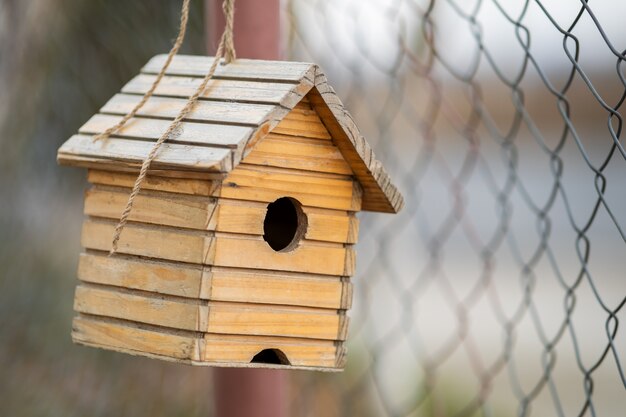 写真 屋外の木の枝にぶら下がっている小さな木製の鳥の家。