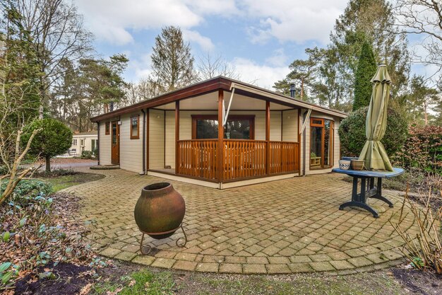 Photo a small wooden cabin with a patio with an umbrella