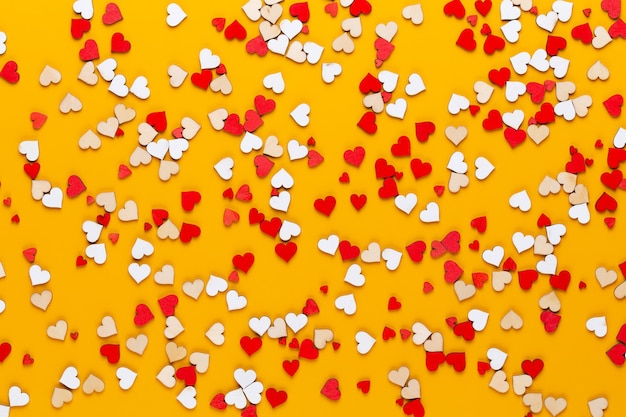 Small wooden hearts on a yellow background