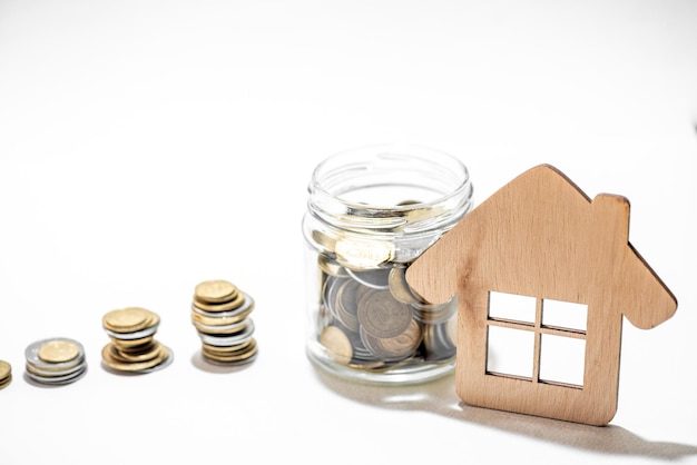 A small wooden house with a pile of coins next to it