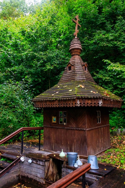 Small wooden orthodox chapel at holy spring in green forest in Shamordino Kaluga Oblast Russia