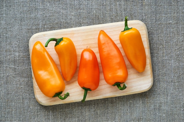 Small yellow bell pepper on a wooden board