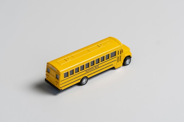 Un piccolo giocattolo giallo schooldbus isolato concetto di educazione dei bambini