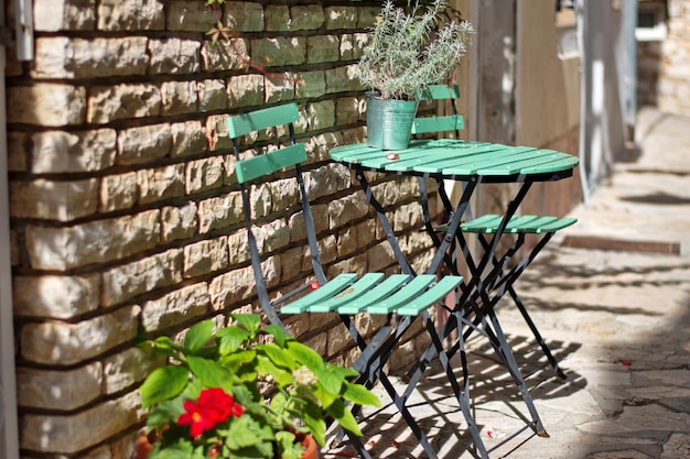 Smalle Dalmatische straat met tafel en stoelen voor de stenen muur