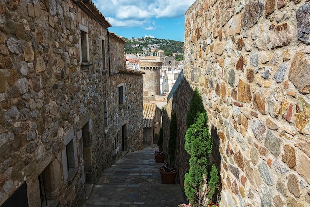 Smalle oude stadsstraat en uitzicht op de toren van het oude fort Tossa de Mar Spanje