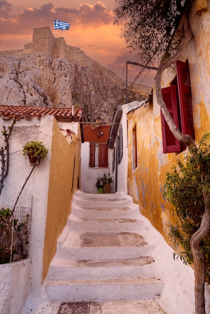 Smalle toeristenstraat met witte stappen in Cycladische stijl in het district Anafiotika in Athene bij zonsondergang