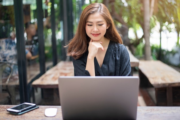 스마트 아시아 여성은 노트북 컴퓨터와 함께 작동