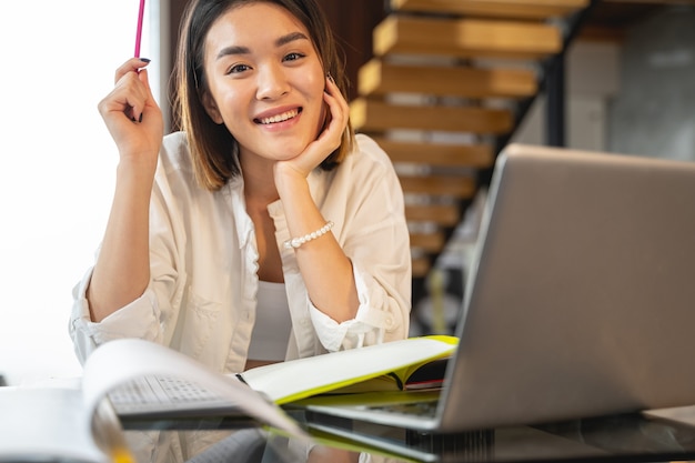 Smart Asian lady making project at her workplace in office