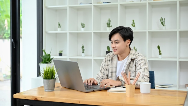 Smart Asian man or male freelancer using laptop working in the office