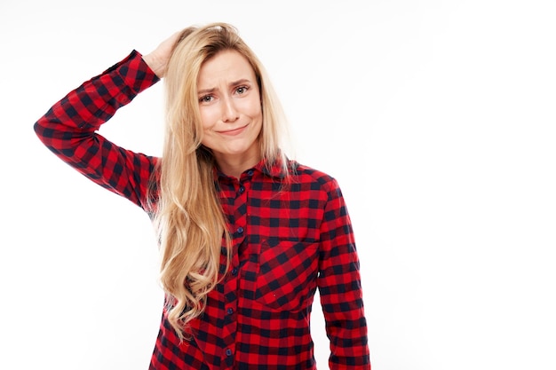 Smart blonde girl in casual holding her head thinks doubts makes decision isolated on white studio background