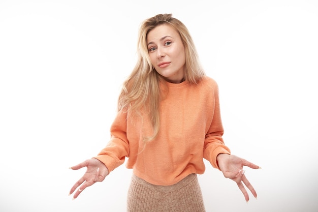 Smart blonde girl in casual shrugging hands thinks doubts makes decision isolated on white studio background