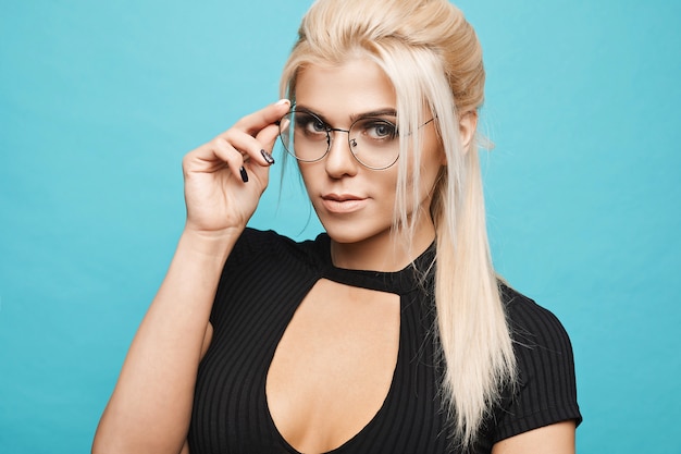 smart blonde girl in glasses on blue