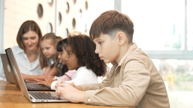 Smart boy playing laptop with multicultural friend learning prompt Erudition