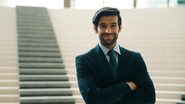 Smart business man standing with folded arm while looking at camera Exultant