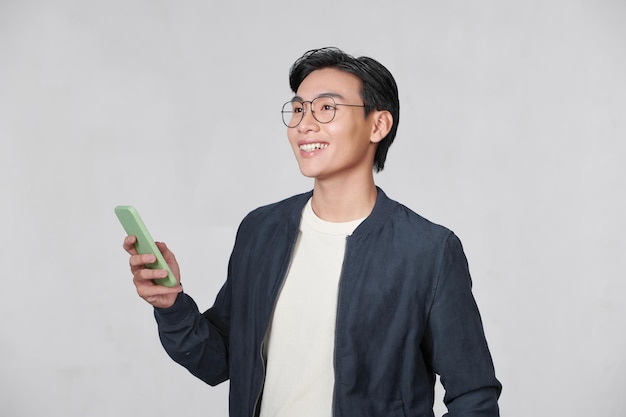 Smart casual asian man using smartphone in studio background