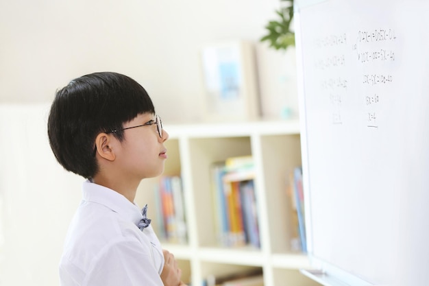 A smart and cute student who thinks and ponders carefully while solving math problems in front of th
