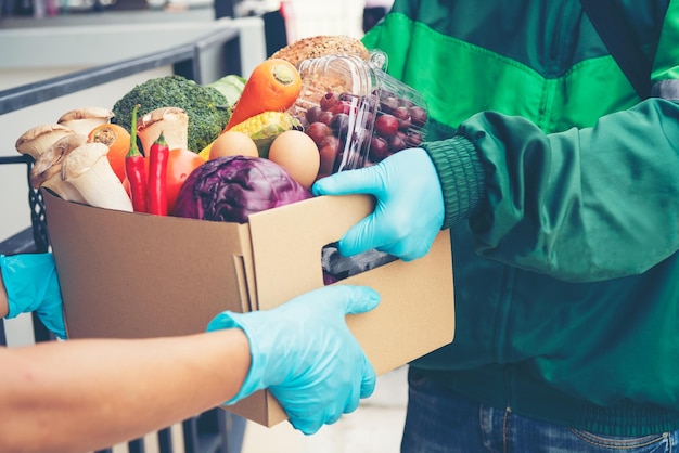 Photo smart delivery food service man handing vegetable food to recipient customer at home woker service food shopping online