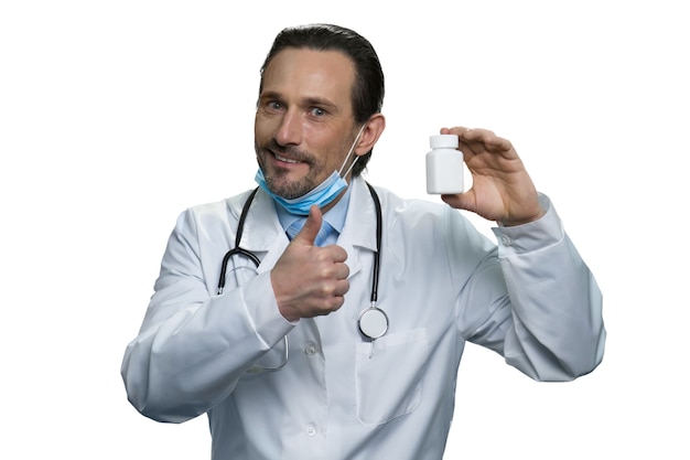 Smart doctor recommends the medicine. Portrait of mature medic isolated on white wall.