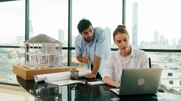 Photo smart engineer inspect house model while colleague using laptop tracery