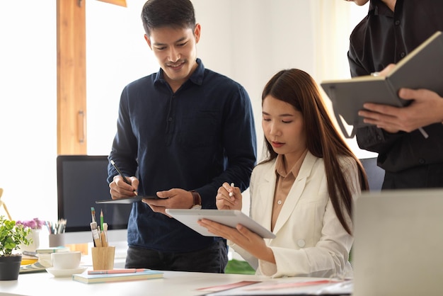 Smart female manager training and coaching two male staff in the office