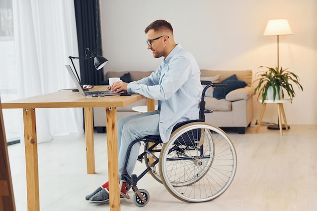 스마트 프리랜서 작업자 휠체어를 탄 장애인이 집에 있습니다.