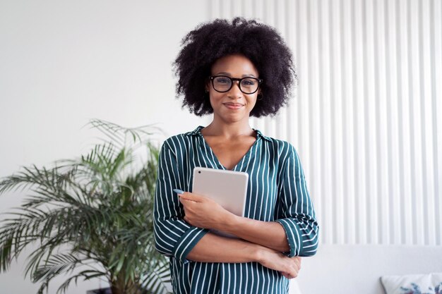 A smart freelancer woman with glasses uses a tablet to make a report online Manager in business