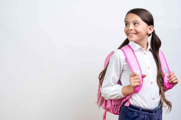 Photo smart hispanic schoolgirl with backpack turning around