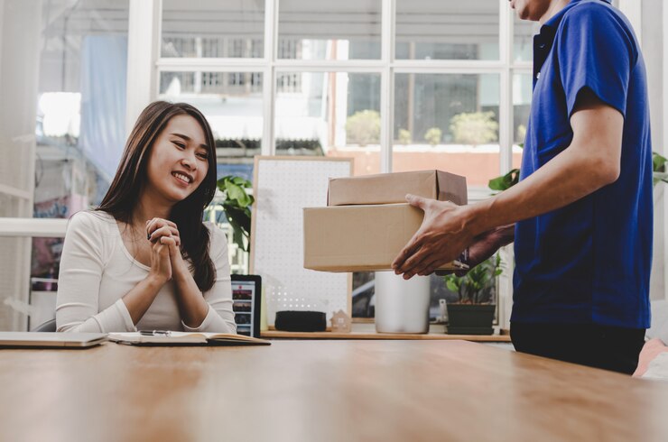 Photo smart home delivery service man in blue uniform and pretty young asian woman customer