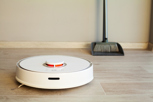 Photo smart home, robot vacuum cleaner performs automatic cleaning of the apartment at a certain time