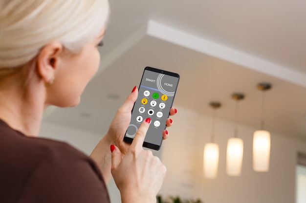 Smart Home: vrouw bedient lichten met app op zijn telefoon