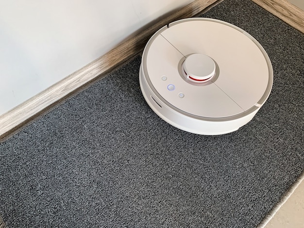 Smart House. Vacuum cleaner robot runs on floor in a living room.