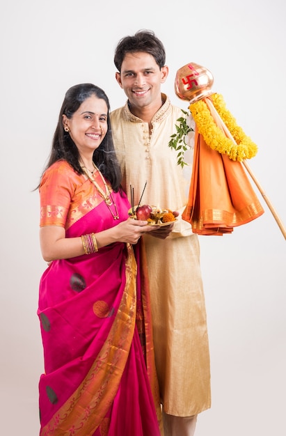 Smart indian giovane coppia che esegue gudi padwa puja in panni tradizionali e pooja thali. è un capodanno indù celebrato in tutta l'india