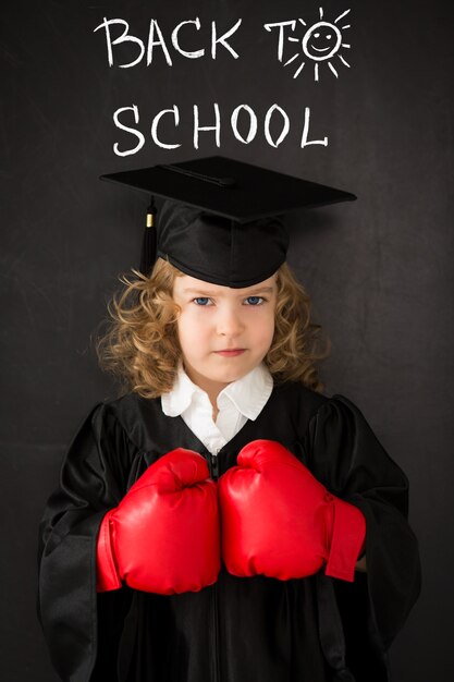 Smart kid in class. Happy child against blackboard. Back to school. Knowledge is power concept