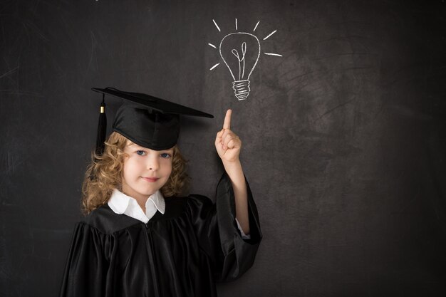 Smart kid in class. Happy child against blackboard. Idea concept