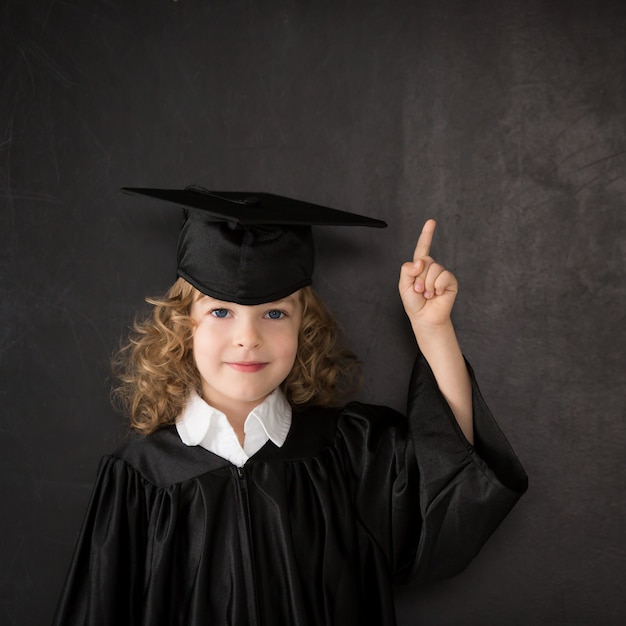 Smart kid in class. Happy child against blackboard. Idea concept