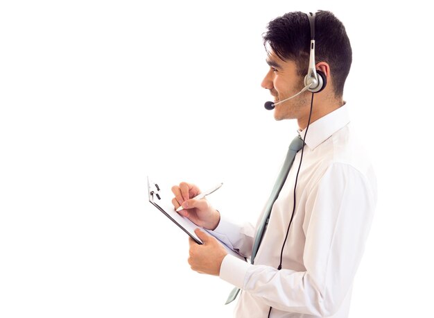 Photo smart-looking man with black hair in white shirt with blue tie and headphones holding a folder on white background in studio