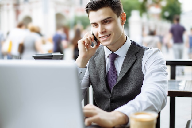 Responsabile astuto che ha pausa caffè e parlando al telefono nella caffetteria