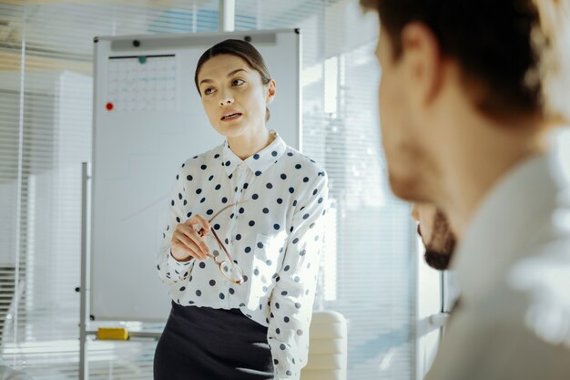 Smart opinion. Pretty young woman standing up during the meeting and expressing her point of view on an important job-related issue