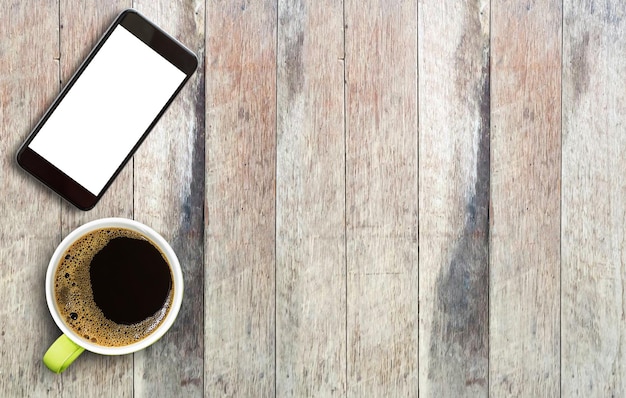 Smart phone and cup of coffee on wood table