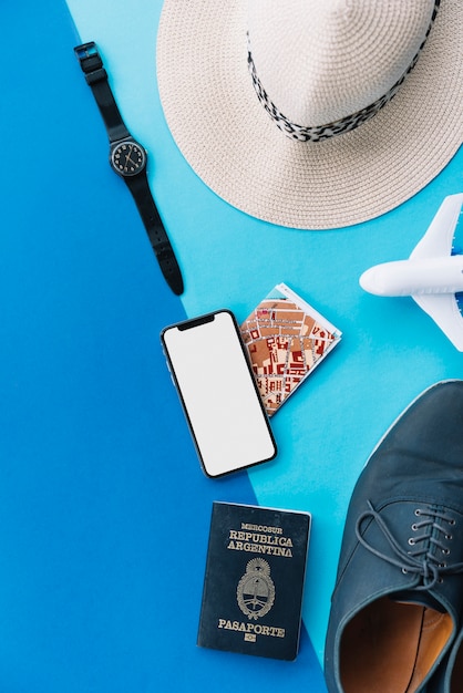 Smart phone; map; passport; toy airplane; shoes; wrist watch and hat on dual background