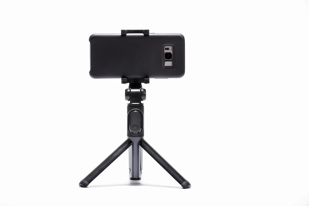 Smart phone and tripod isolated on white background