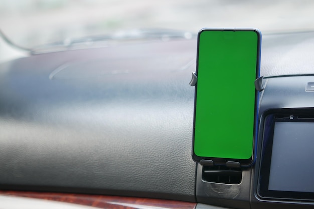 Smart phone with green screen on car dashboard