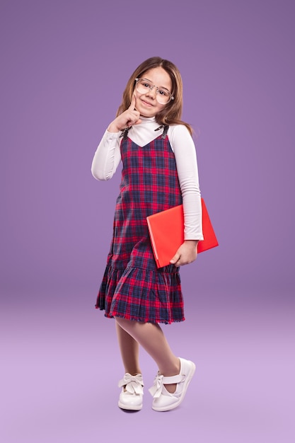 Фото Умная школьница в униформе и очках с книгой