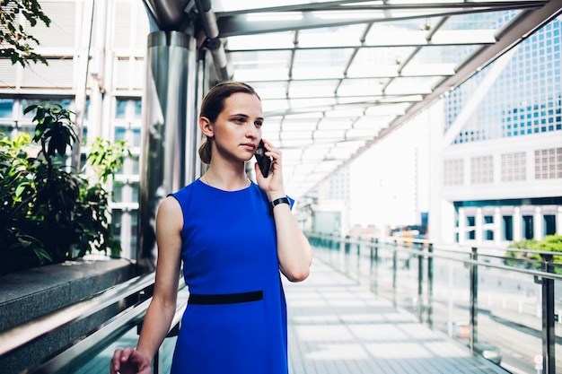 Signora magra intelligente che telefona in strada